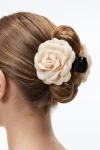 Hårklemme med beige stofrose sat i en knold – set bagfra